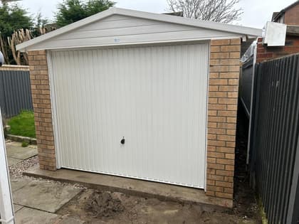 Completed Nucrete apex concrete garage with brick front and white up-and-over door
